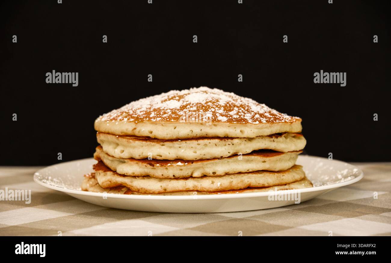 Accatastare i pancake di siero di latte con zucchero a velo Foto Stock