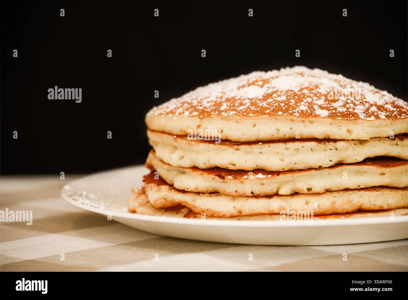 Accatastare i pancake di siero di latte con zucchero a velo Foto Stock