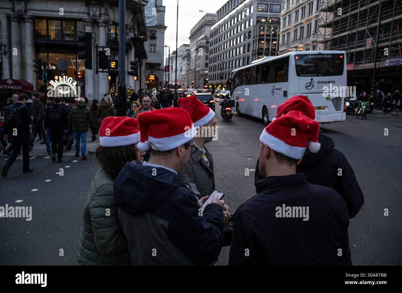 I lavoratori di Londra si recano con i cappelli di Babbo Natale durante la festa di Natale in compagnia a Piccadilly, nel centro di mayfair, Londra, Regno Unito Foto Stock