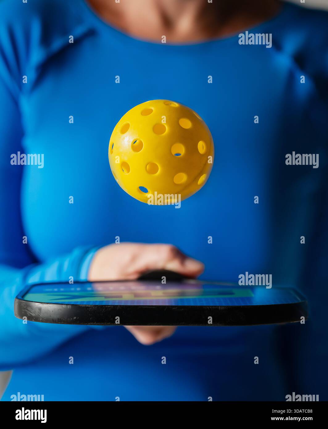 Primo piano di una donna in blu che rimbalza il picchetto giallo su una pagaia. Foto Stock