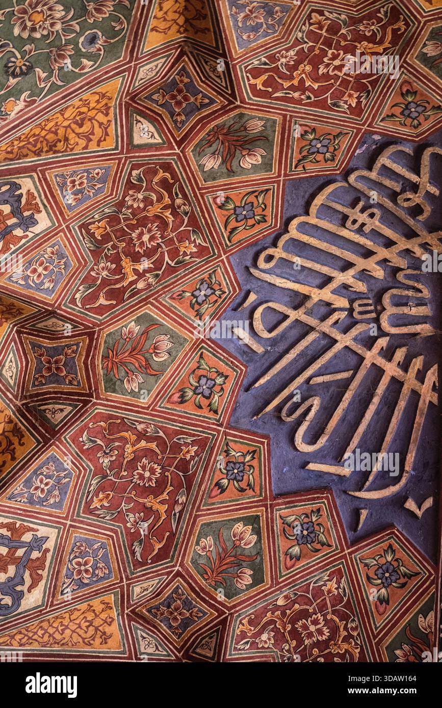 La vista di intricati motivi geometrici danzano con colori vivaci e calligrafia ornata sotto un arco, Lahore, Punjab, Pakistan. Foto Stock