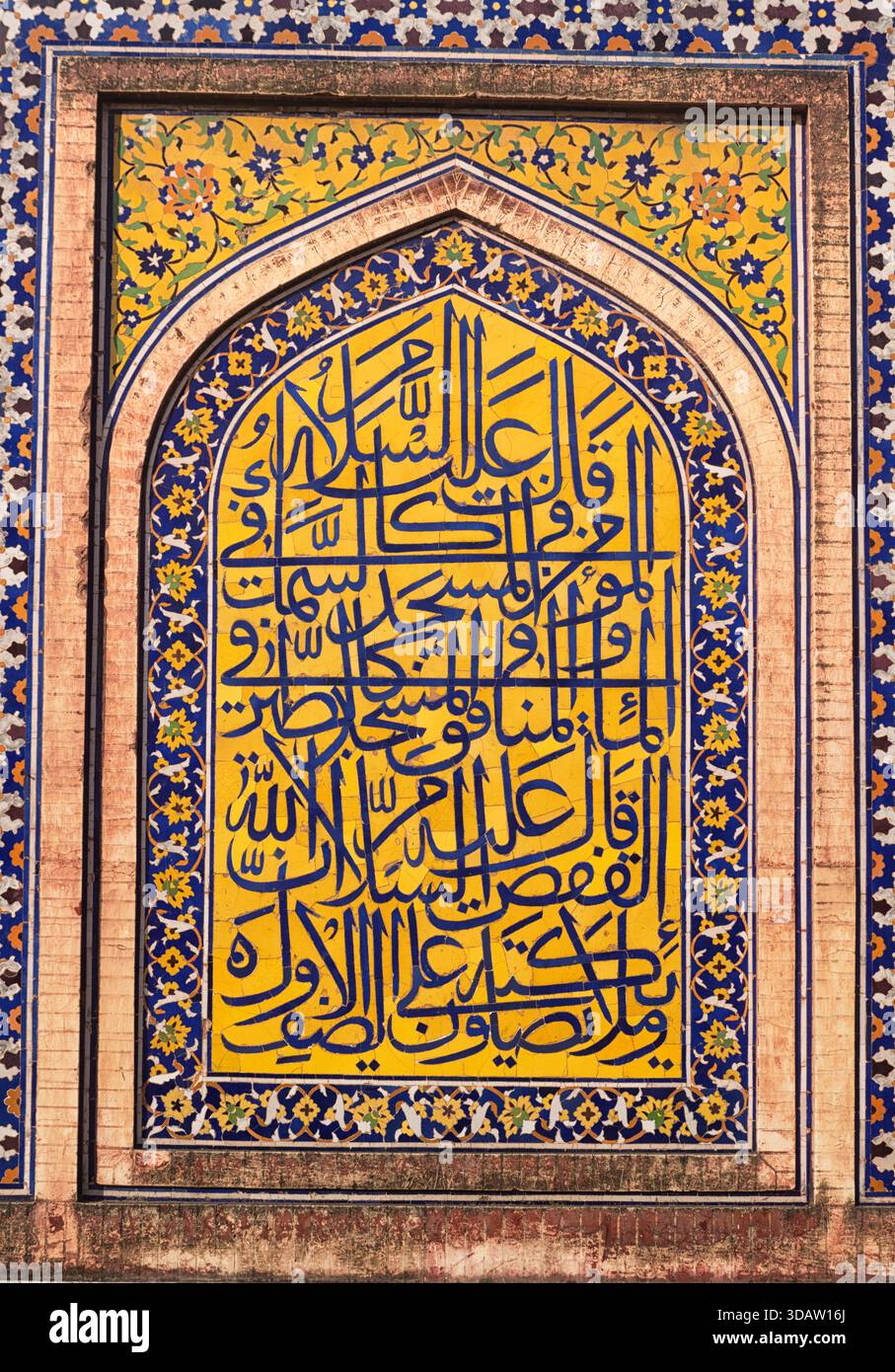 Veduta di un'intricata calligrafia islamica con piastrelle floreali gialle e blu, un arazzo culturale di fede e arte, Lahore, Punjab, Foto Stock