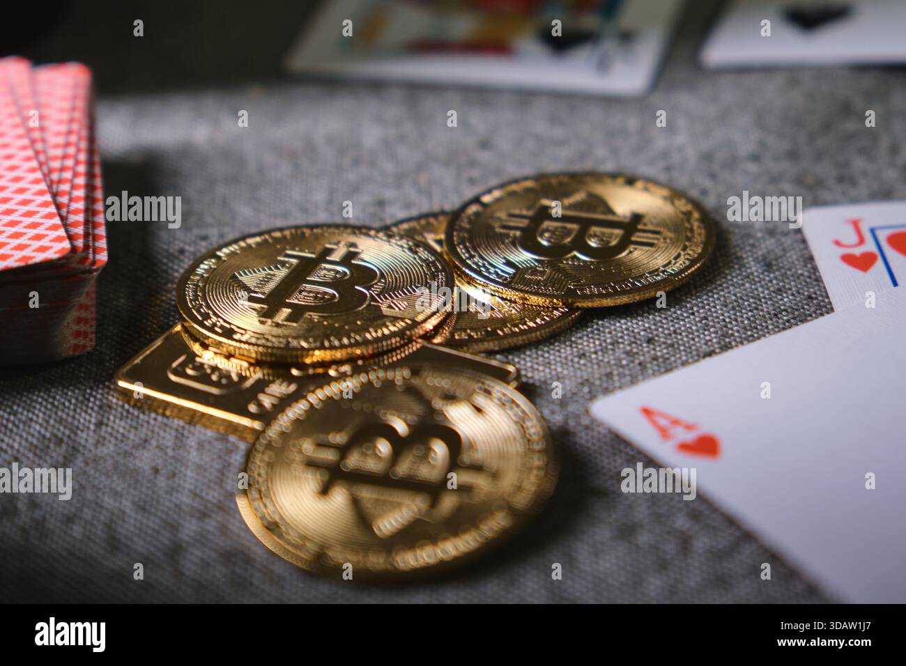Monete bitcoin d'oro e carte da poker che rappresentano il gioco d'azzardo online e la finanza digitale Foto Stock