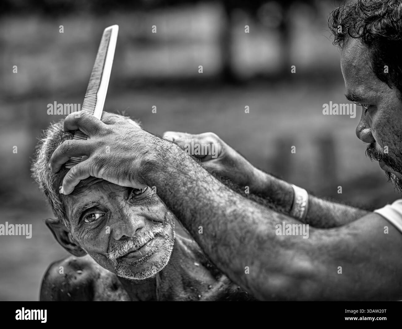 Un anziano indiano che si fa tagliare i capelli, Orissa, India Foto Stock