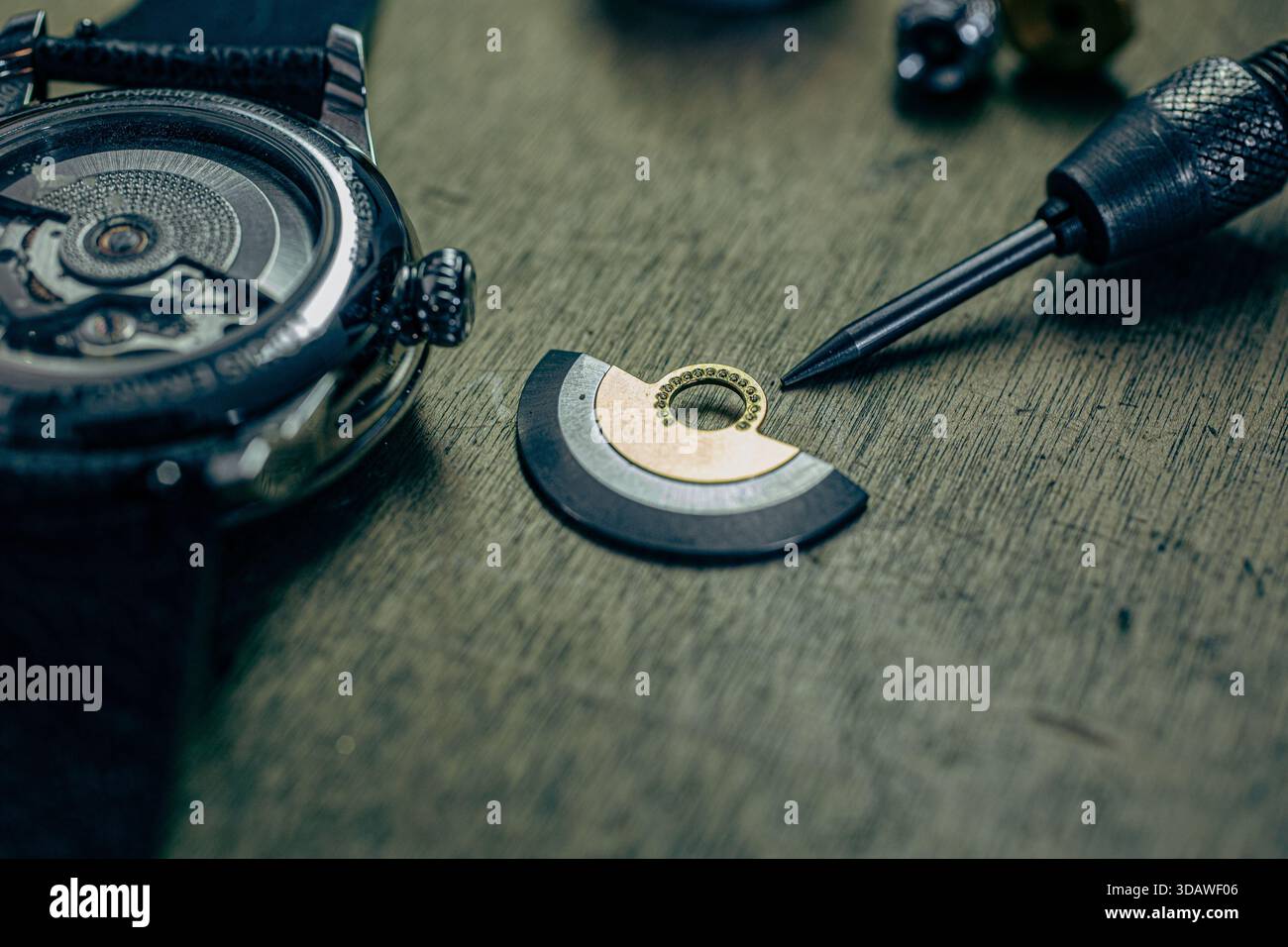 Foto dettagliata sulla panchina di un orologiaio, che mostra il preciso processo di incisione a mano di un quadrante ghiglioché per Louis Erard "le Régulateur". Foto Stock