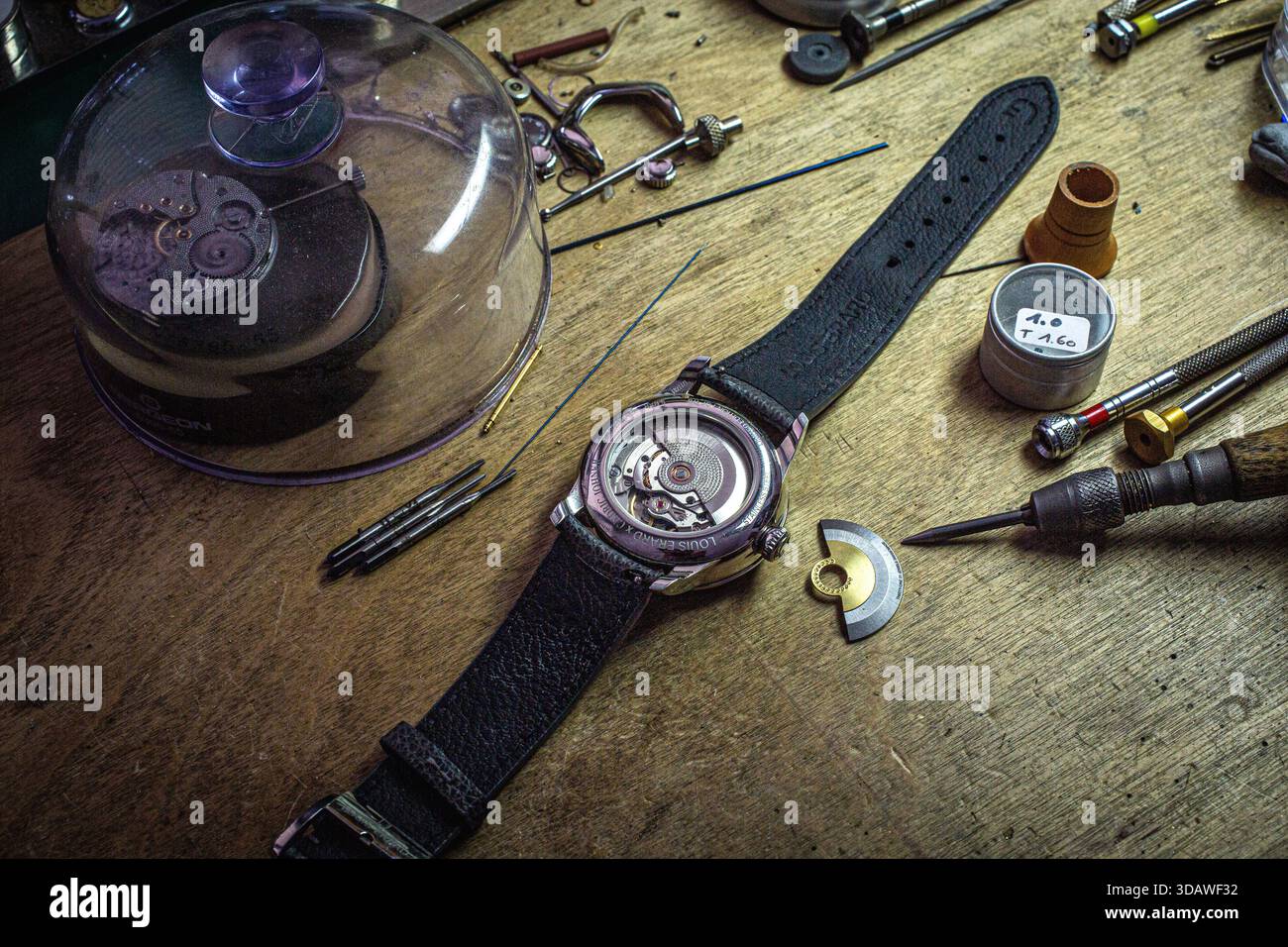 Foto dettagliata sulla panchina di un orologiaio, che mostra il preciso processo di incisione a mano di un quadrante ghiglioché per Louis Erard "le Régulateur". Foto Stock