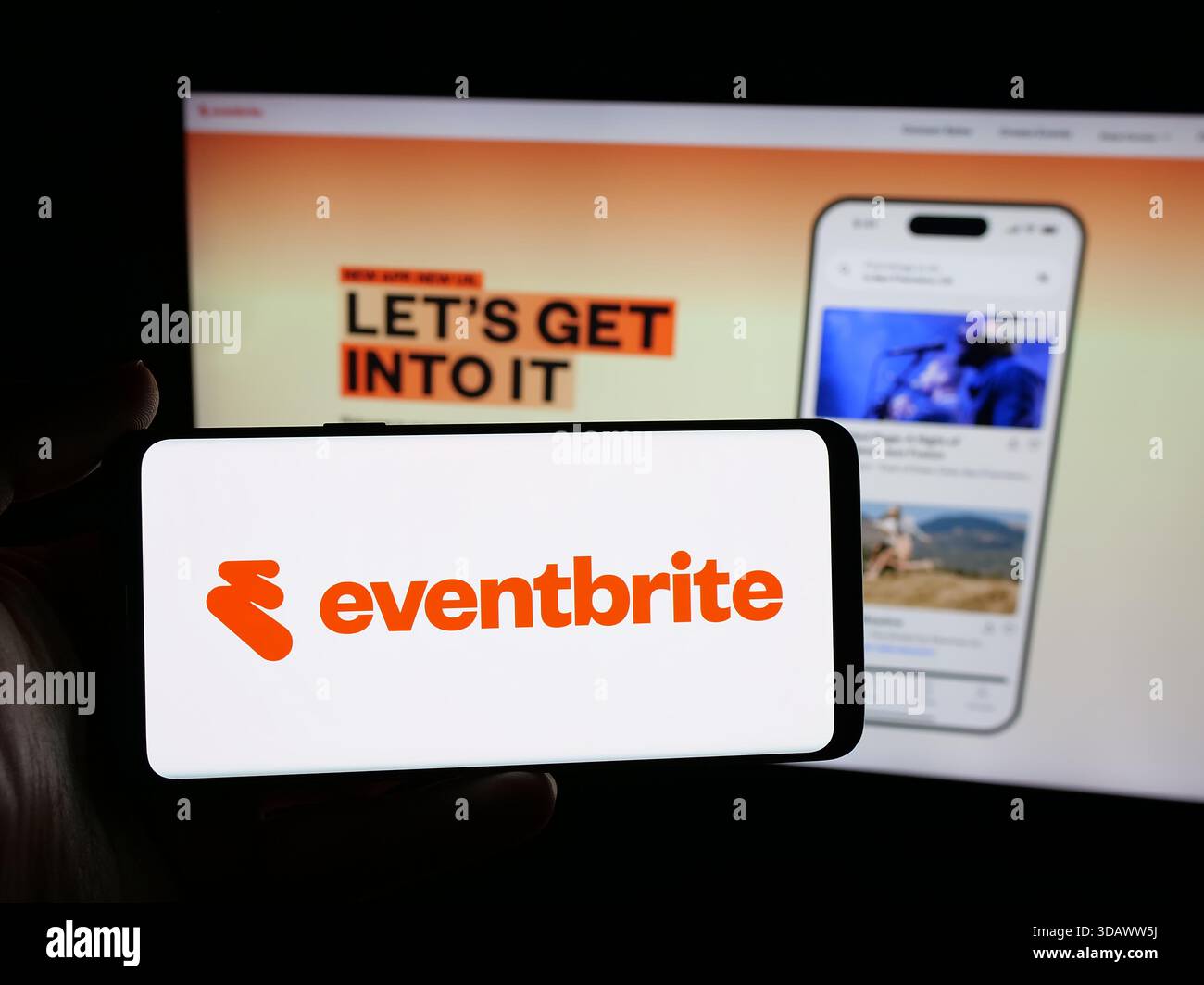 Stoccarda, Germania - 11-30-2025: Persona in possesso di uno smartphone con logo della società statunitense Eventbrite Inc. Sullo schermo davanti al sito Web. Foto Stock