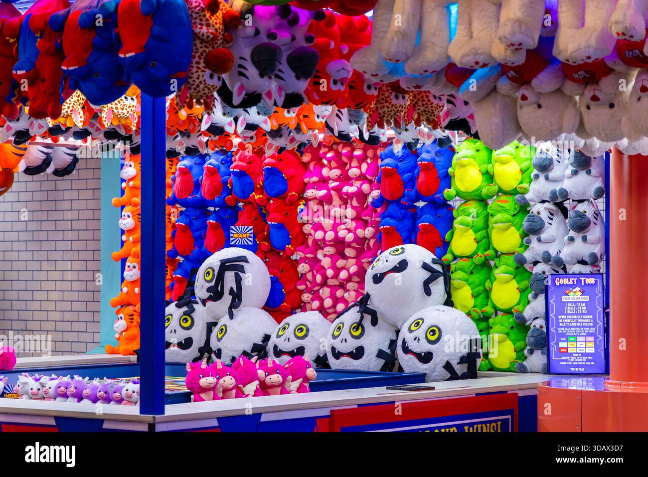 Giocattoli colorati e peluche sono appesi in modo luminoso in uno stallo per carnevale di Genting Highlands. I premi per il parco divertimenti creano un'atmosfera vivace e divertente. Ingresso famiglia Foto Stock