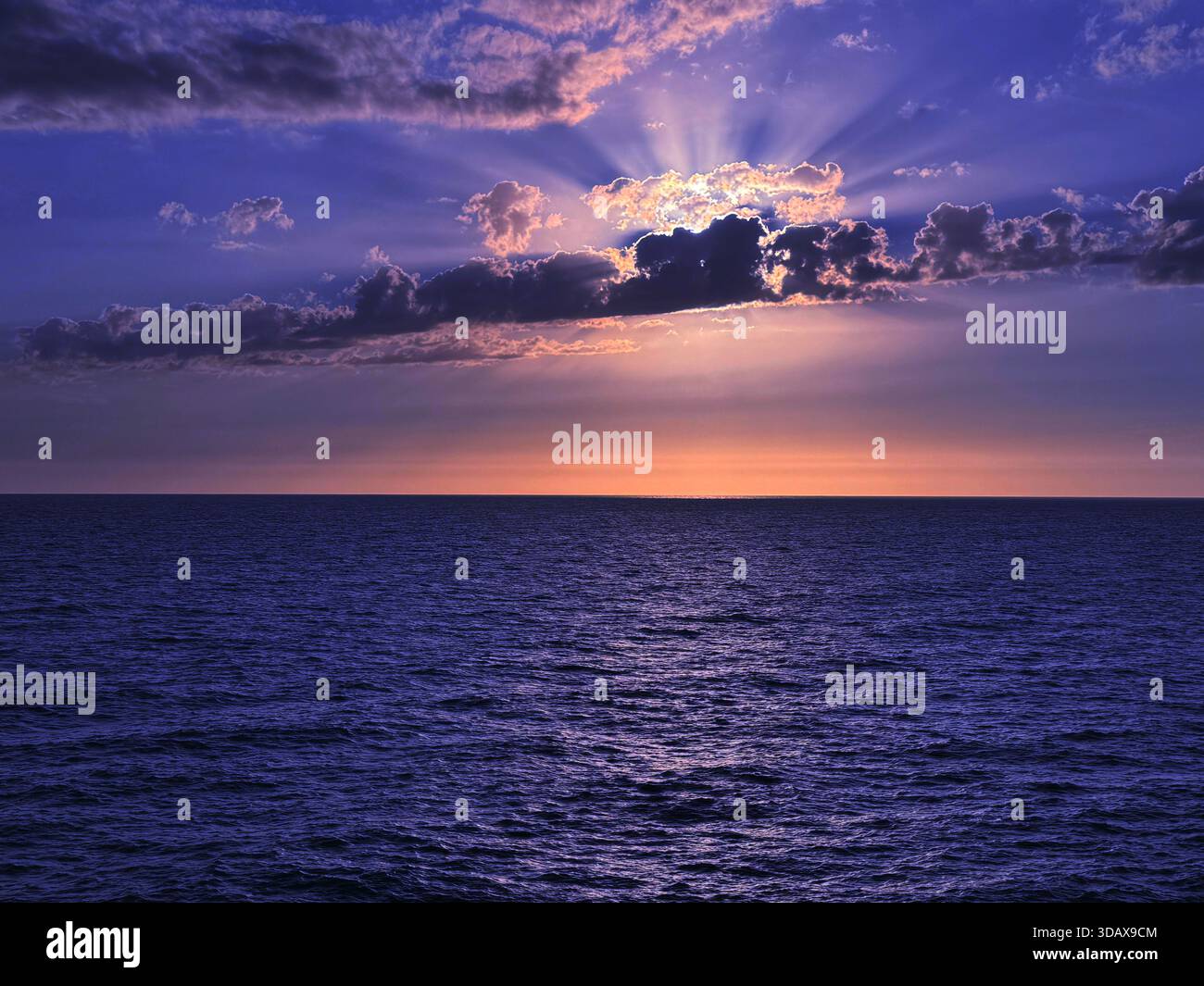 Il tramonto nuvola il cielo sul mare blu scuro Foto Stock