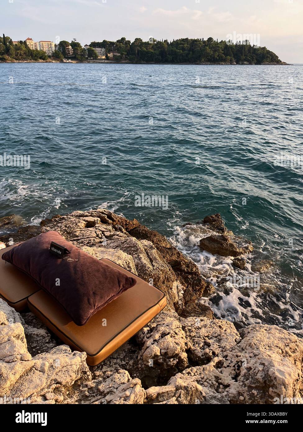 Un momento tranquillo di comfort balneare dove l'Adriatico lambisce dolcemente contro le rocce - Immagine stock catturata con smartphone