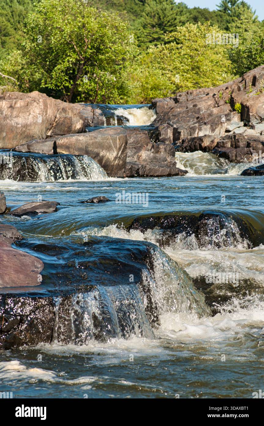 Piccole cascate del fiume Eau Claire che scorrono attraverso il Big Falls County Park vicino a Eau Claire, Wisconsin, a fine estate, un luogo popolare per nuotare. Foto Stock