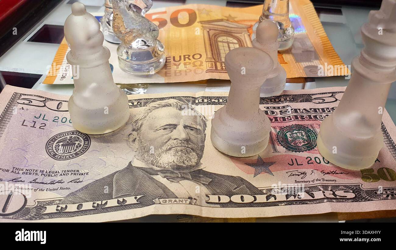 Due banconote da 50 dollari USA e 50 euro di fronte a una scacchiera, in un gioco di supremazia e guerra tariffaria commerciale. Foto Stock