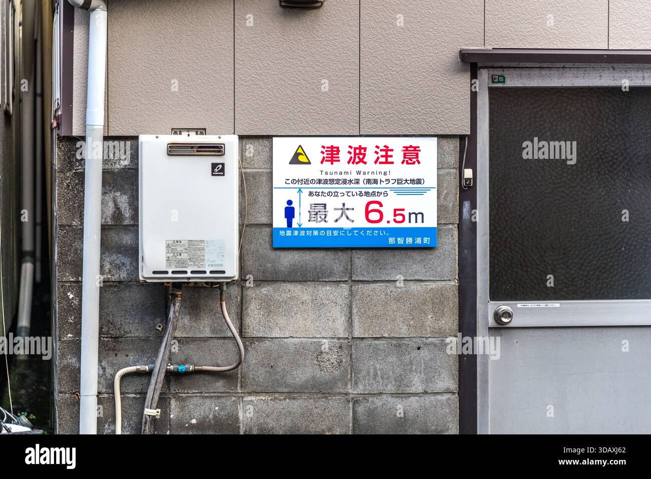 Un cartello di avvertimento per lo tsunami su un muro di casa a Nachikatsuura indica un'altezza massima d'onda prevista di 6,5 metri in caso di mega terremoto nella fossa di Nankai. Prefettura di Wakayama, Giappone. Foto Stock