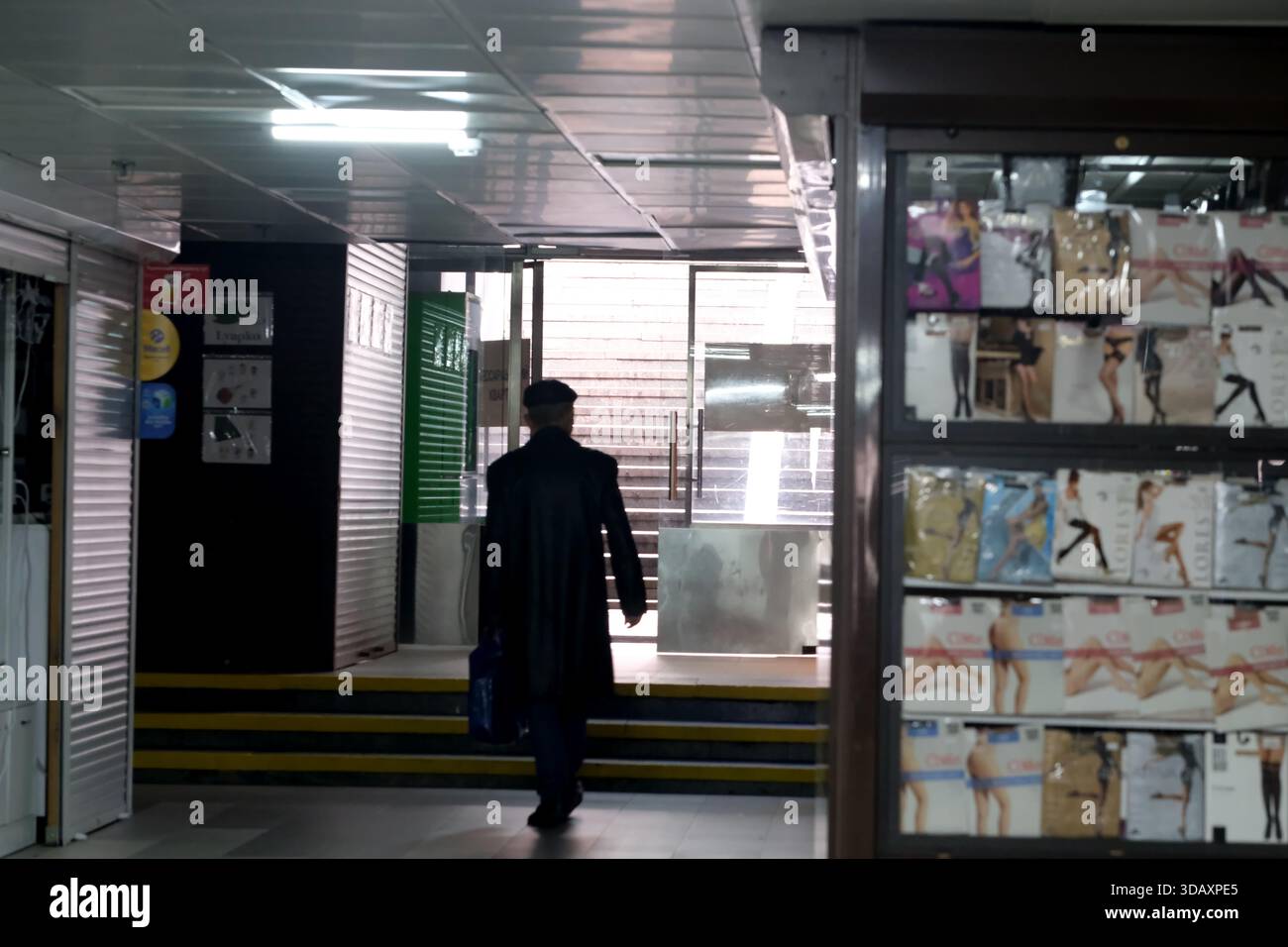 Una figura solitaria cammina verso la luce alla fine di un corridoio, suggerendo una storia. Kiev, Ucraina. 12 dicembre 2025. Foto Stock