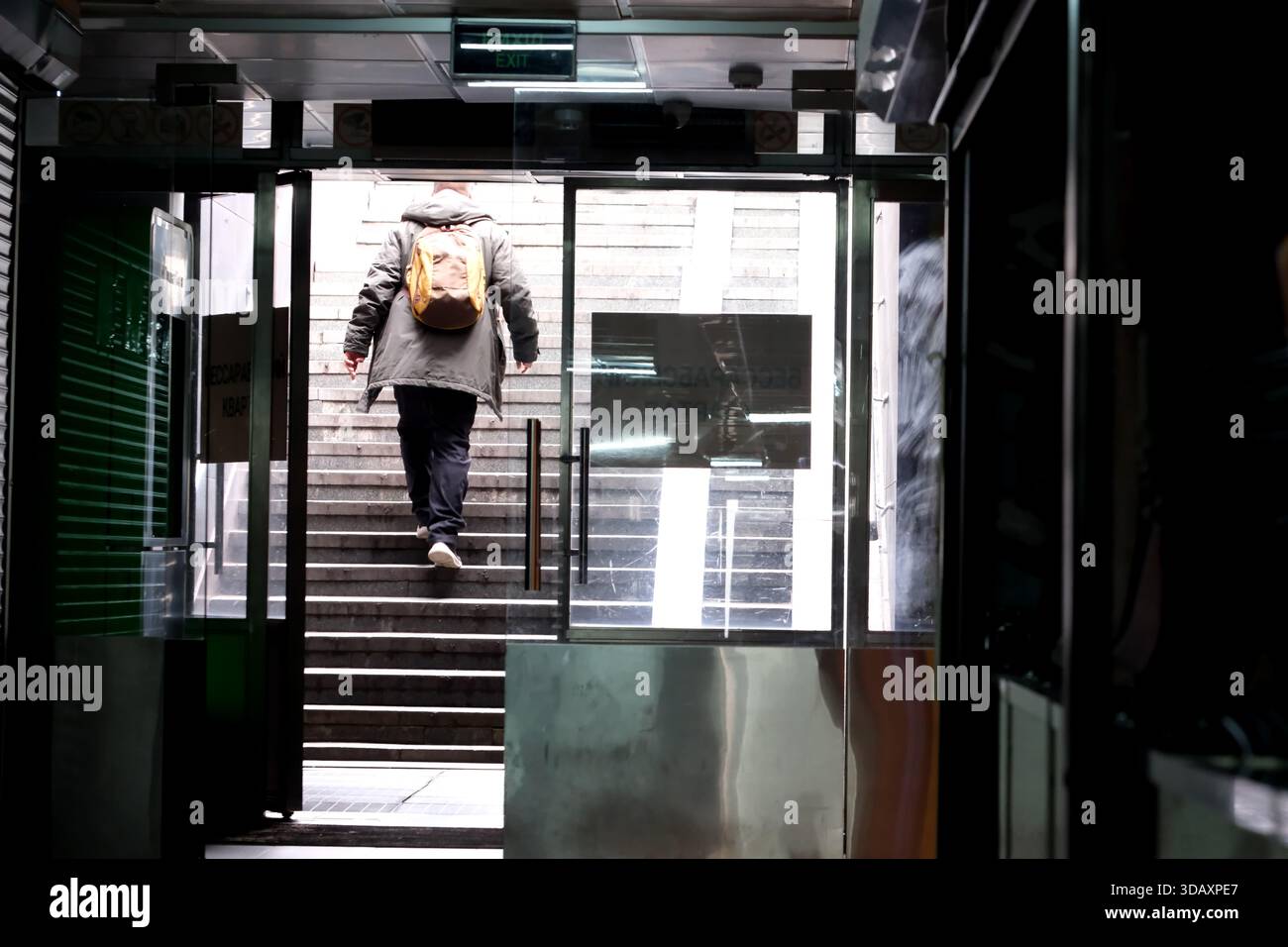 Una figura solitaria sale le scale, trasportando uno zaino, in una tranquilla scena cittadina. Kiev, Ucraina. 12 dicembre 2025. Foto Stock