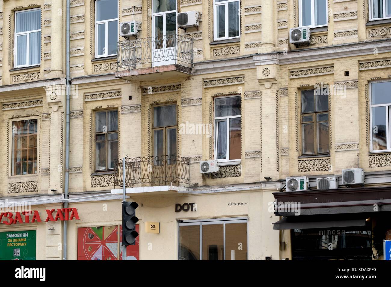 L'affascinante facciata dell'edificio mostra dettagli ornati con la vivace vita di strada nelle vicinanze. Kiev, Ucraina. 12 dicembre 2025. Foto Stock
