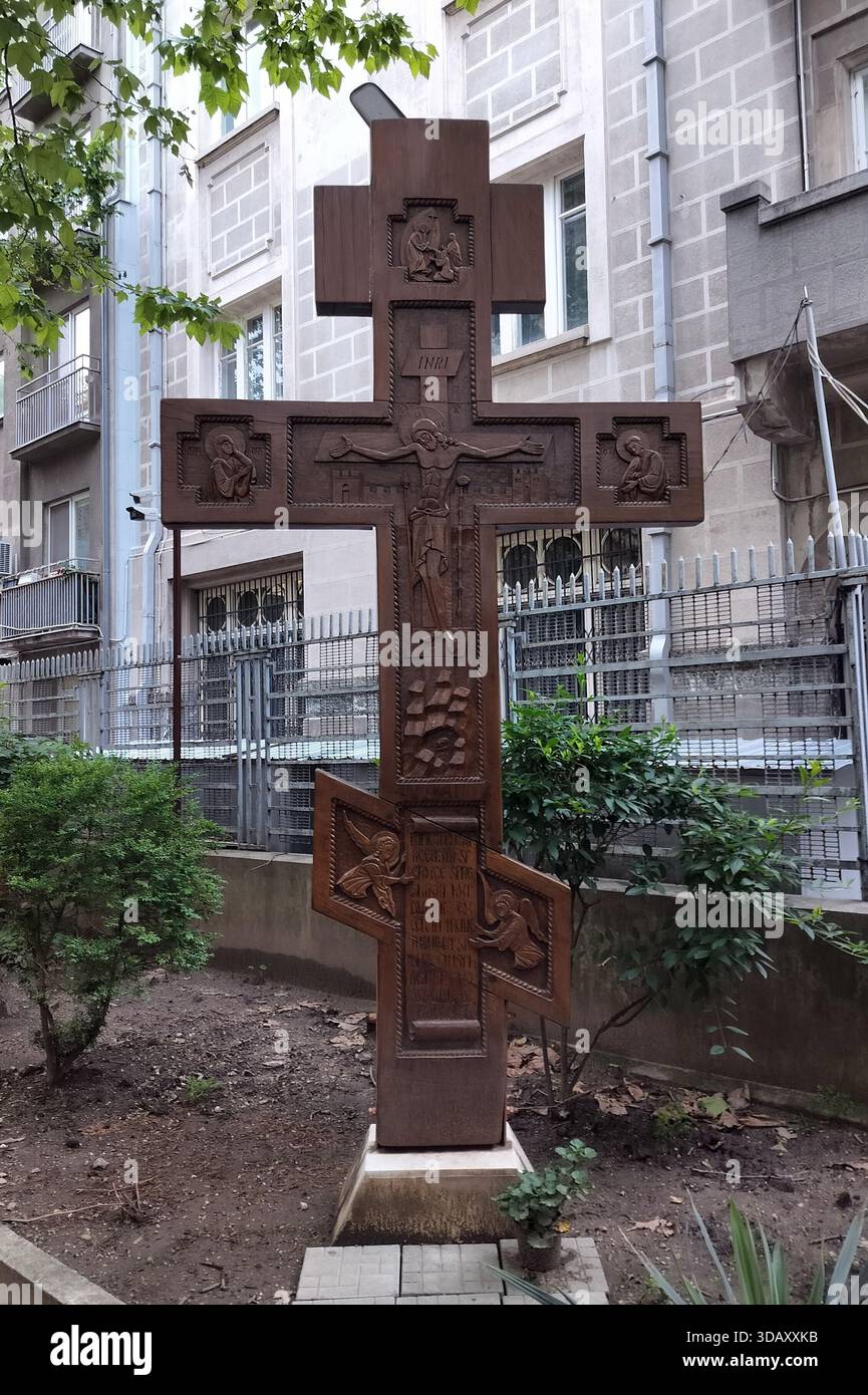 Croce ortodossa orientale scolpita in legno, nel giardino della Chiesa russa di San Nicola, Bucarest, Romania Foto Stock