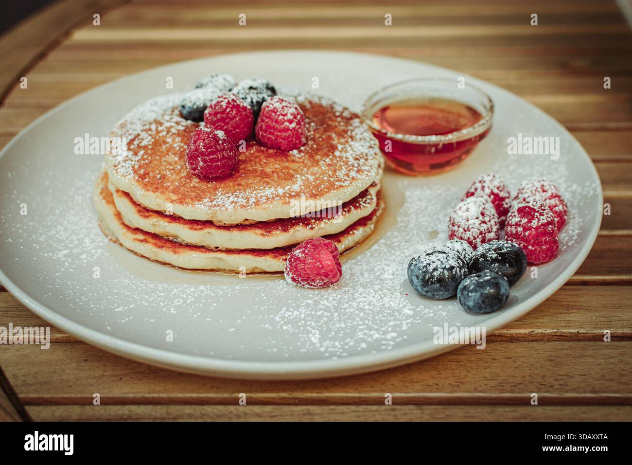 Piatto con frittelle dolci, frutta e sciroppo Foto Stock