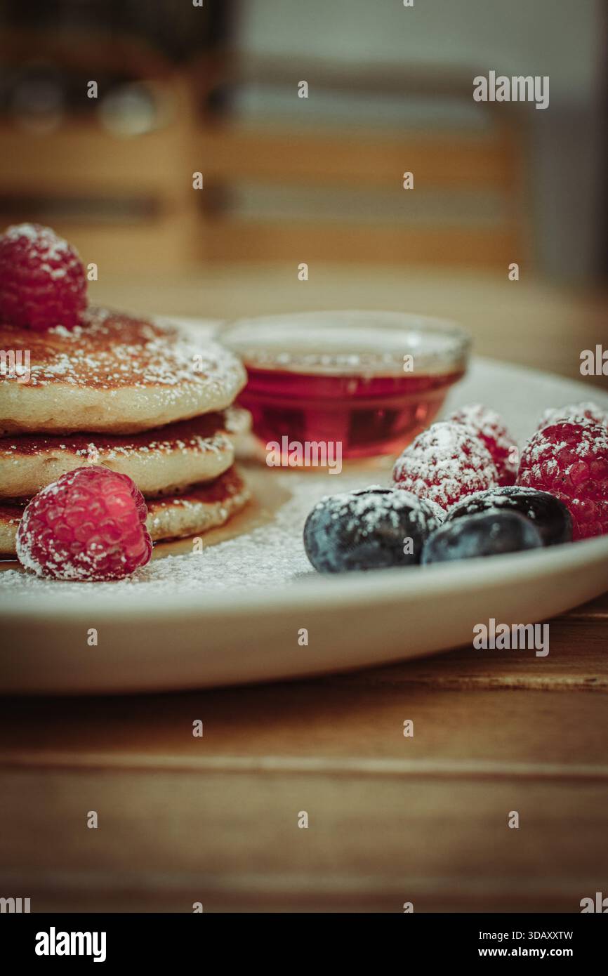 Piatto con frittelle dolci, frutta e sciroppo Foto Stock