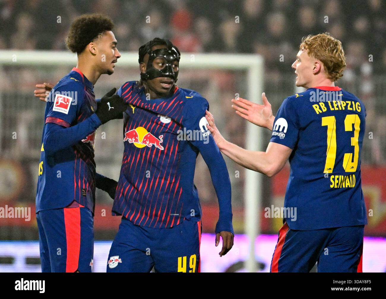 Berlino, Germania. 13 dicembre 2025. Calcio: Bundesliga, 1. FC Union Berlin - RB Leipzig, Matchday 14, an der Alten Försterei, Tidiam Gomis (l, RB Leipzig) celebra il suo equalizzatore 1:1 con Yan Diomande (RB Leipzig) e Nicolas Seiwald (r, RB Leipzig) crediti: Soeren Stache/dpa - NOTA IMPORTANTE: in conformità con i regolamenti della DFL German Football League e della DFB German Football Association, è vietato utilizzare o far utilizzare fotografie scattate nello stadio e/o della partita sotto forma di immagini sequenziali e/o serie di foto video./dpa/Alamy Live News Foto Stock