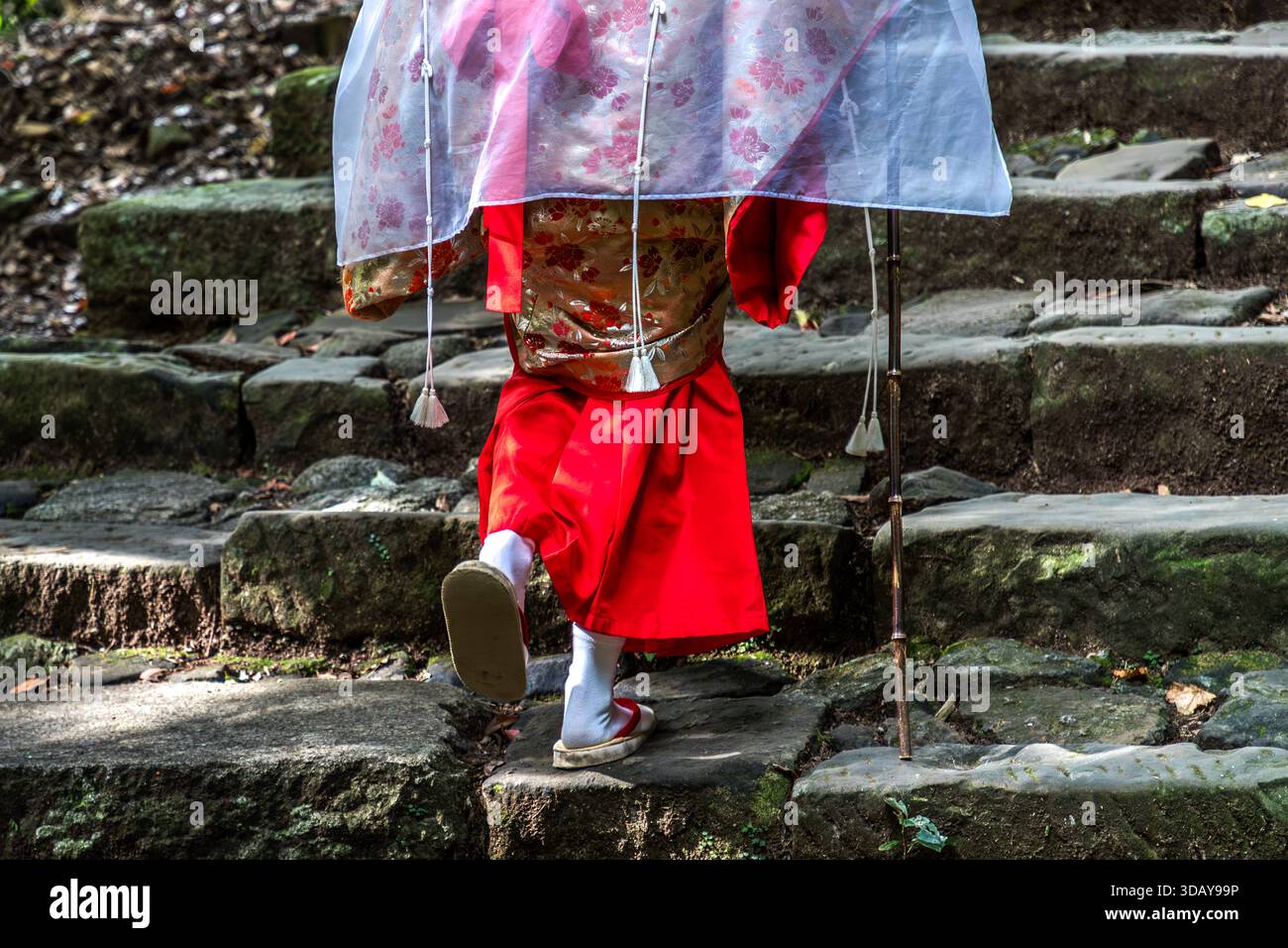 Cammina in sandali di legno e un kimono strettamente legato sul percorso di pellegrinaggio di Kumano Kodo nella prefettura di Wakayama. Persona vestita con abiti tradizionali giapponesi sul percorso di pellegrinaggio roccioso di Kumano Kodo a Nachikatsuura. Prefettura di Wakayama, Giappone Foto Stock