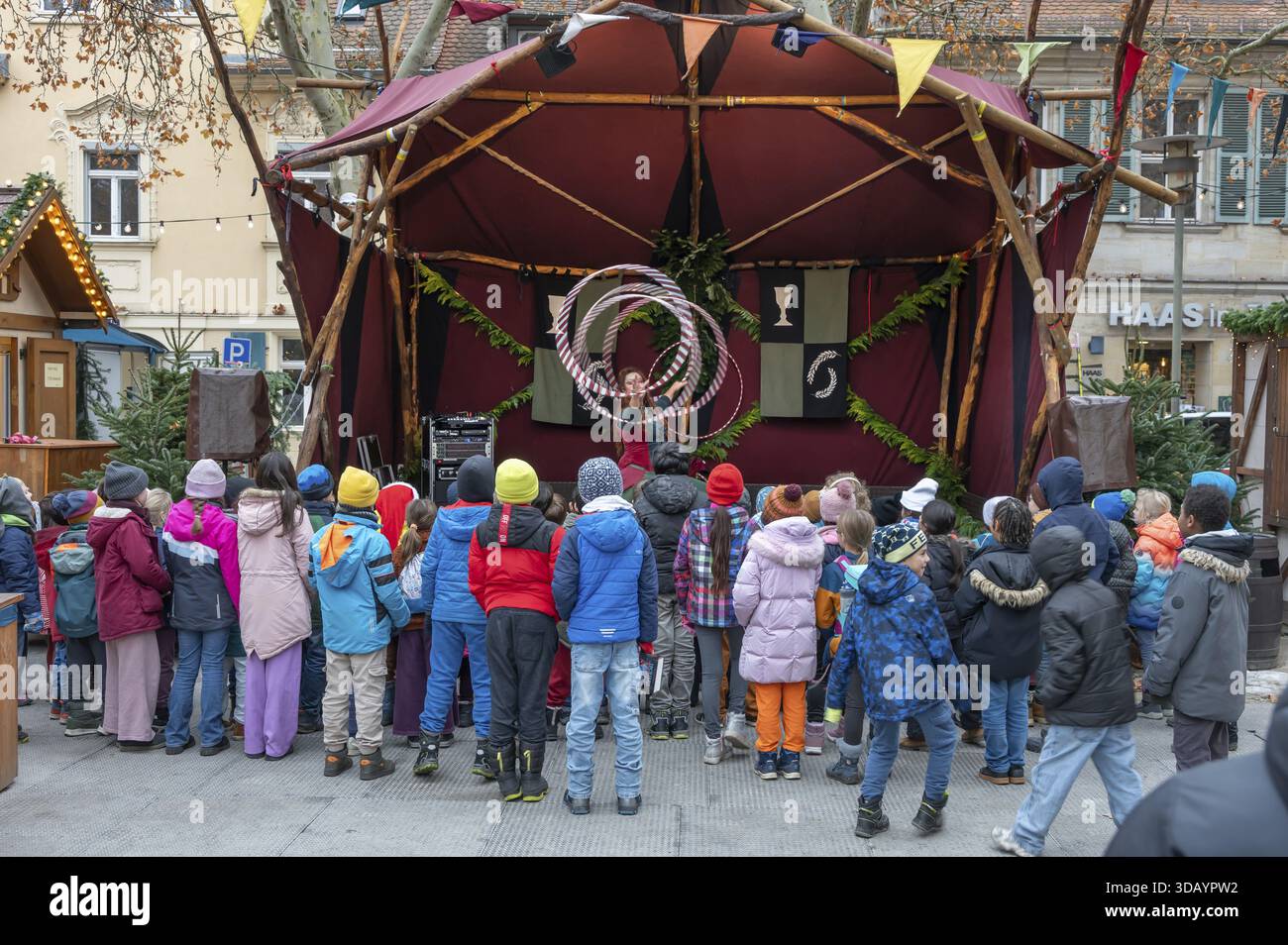 Un gruppo di bambini guarda un acrobato sul palco, il mercato di Natale Historischer am Neustaedter Church Square, Erlangen, Middle Franconia, Baviera, Germ Foto Stock