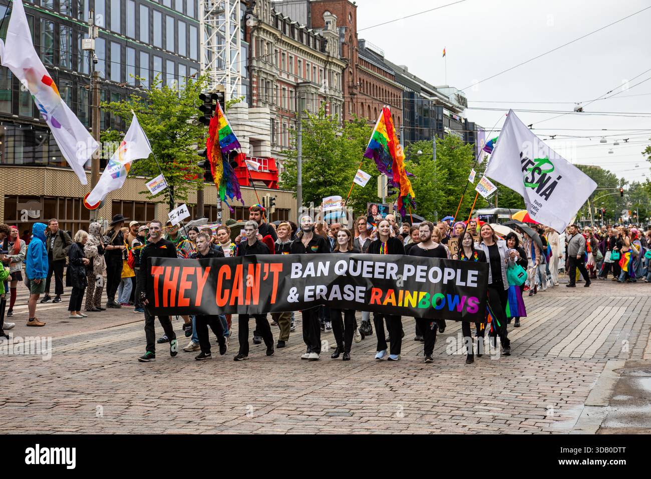 Non possono vietare le persone queer e cancellare gli arcobaleni. Rifugiati queer in marcia con striscione su Mannerheimintie alla parata Helsinki Pride 2025 a Helsinki, FI. Foto Stock
