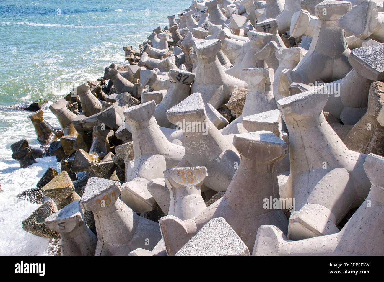 I tetrapodi sono blocchi di cemento armato a quattro bracci (forma tetraedrica) utilizzati come elementi per proteggere le coste e le strutture marittime, come ad esempio Foto Stock