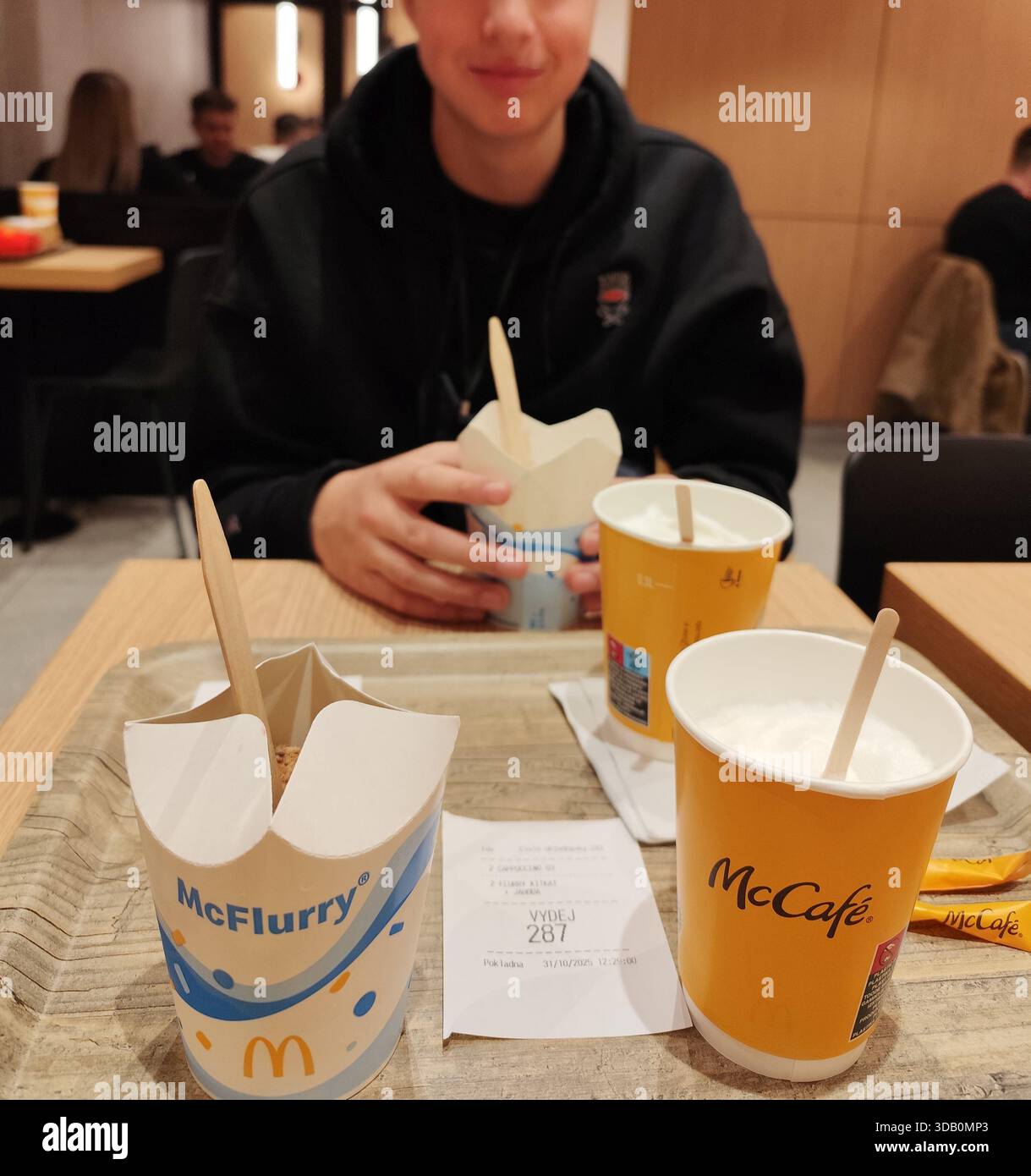Repubblica Ceca, Praga - 31 ottobre 2025: Menu su ordinazione del McDonald's Cafe. Il dessert McCafe mangia McFlurry. Tazze da caffè sul tavolo Foto Stock