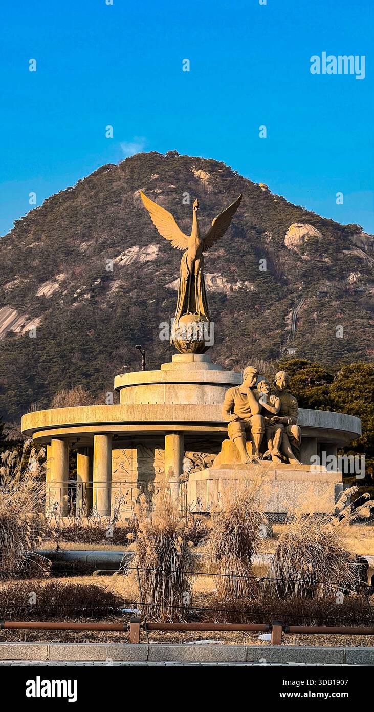 Simboli della governance: Vista dell'ora d'oro della statua di Phoenix e delle cime robuste di Bugaksan Foto Stock