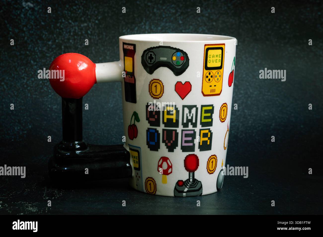 Tazza di gioco retrò con testo "Game Over" e impugnatura in stile joystick ispirata ai classici giochi arcade. Foto Stock