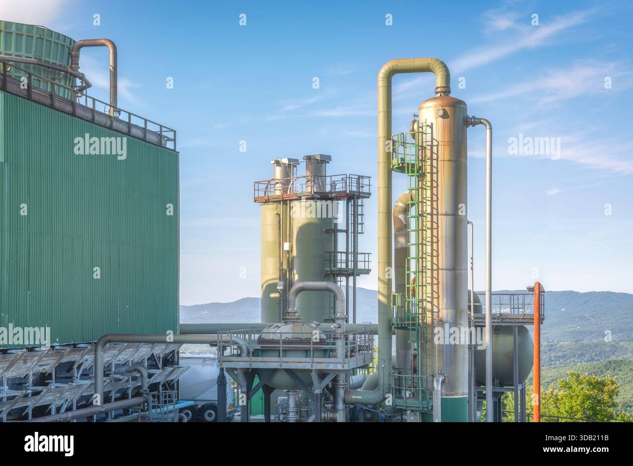 Vista del paesaggio industriale di un complesso geotermico a Larderello, in Toscana, il più antico sito di produzione di energia geotermica del mondo. Tubi grandi, raffreddamento t Foto Stock