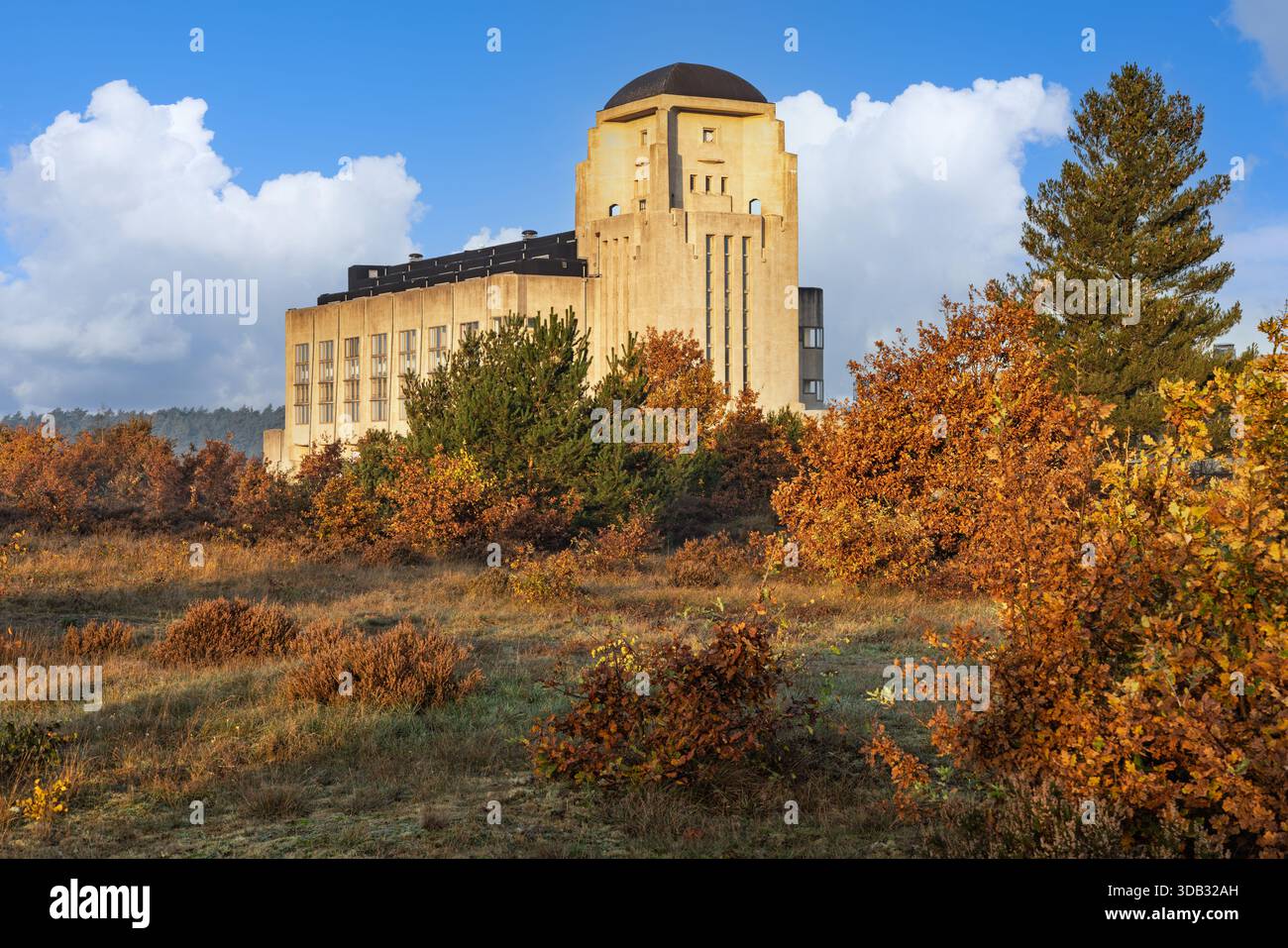 Vista panoramica del monumentale edificio radio Kootwijk, una struttura in cemento Art Deco nei Paesi Bassi, circondata da vibranti fogliame autunnale e blu Foto Stock
