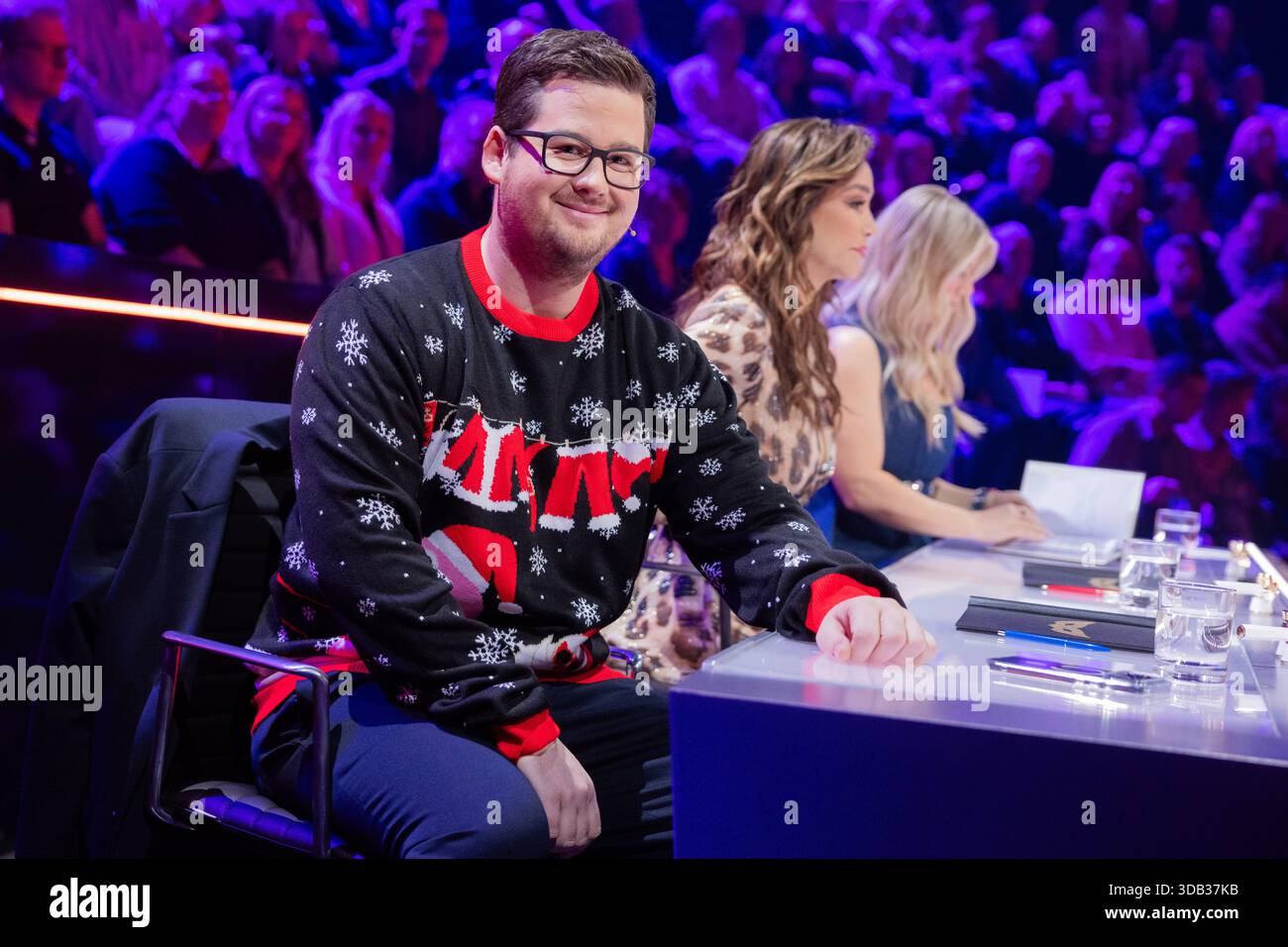 Colonia, Germania. 13 dicembre 2025. Chris Tall del team di montaggio indossa un maglione natalizio regalo nella finale dello show di ProSieben "The Masked Singer". Crediti: Rolf Vennenbernd/dpa/Alamy Live News Foto Stock