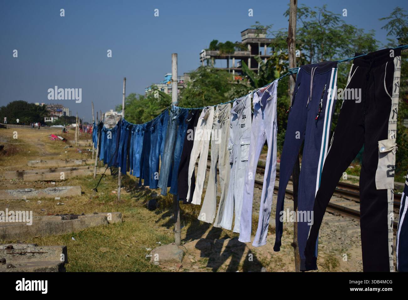 Pantaloni in denim appesi alla luce del sole per asciugare Foto Stock