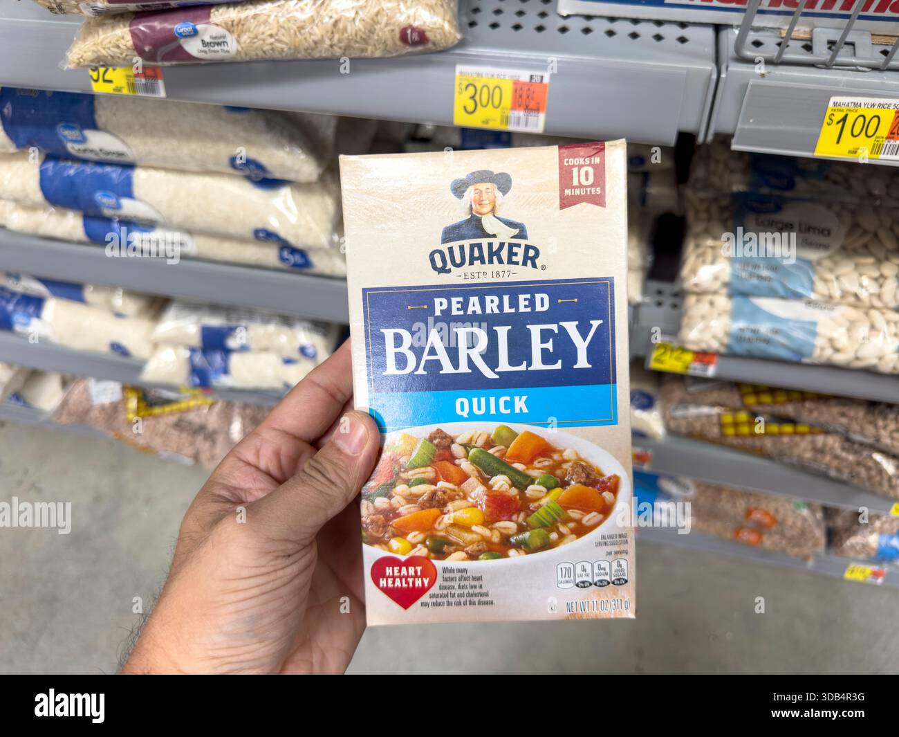 Los Angeles, California, Stati Uniti - 08-14-2024: Una vista di una mano che tiene un pacco di orzo perlato quacchero, in mostra presso il negozio. Foto Stock