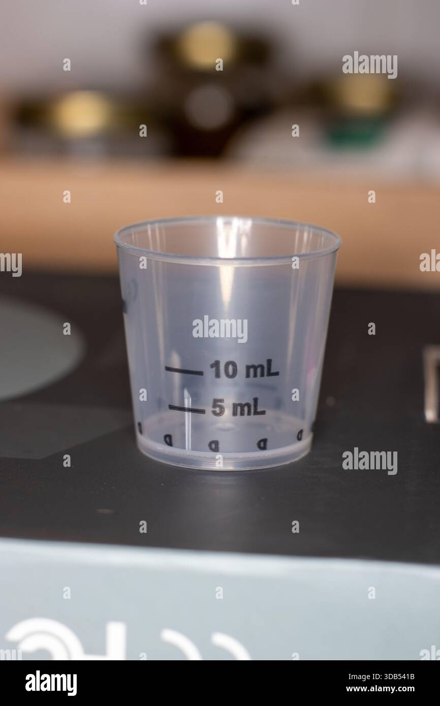 primo piano di un misurino per medicinali liquidi in plastica Foto Stock