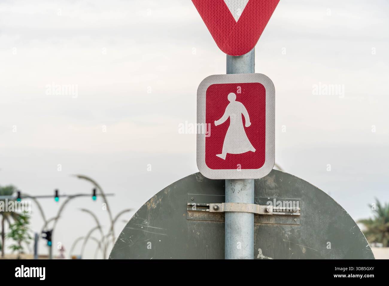 Segnale di attraversamento pedonale a Doha, Qatar, che simboleggia la zona urbana sicura e le infrastrutture organizzate della città araba lungo le strade del Golfo. Foto Stock