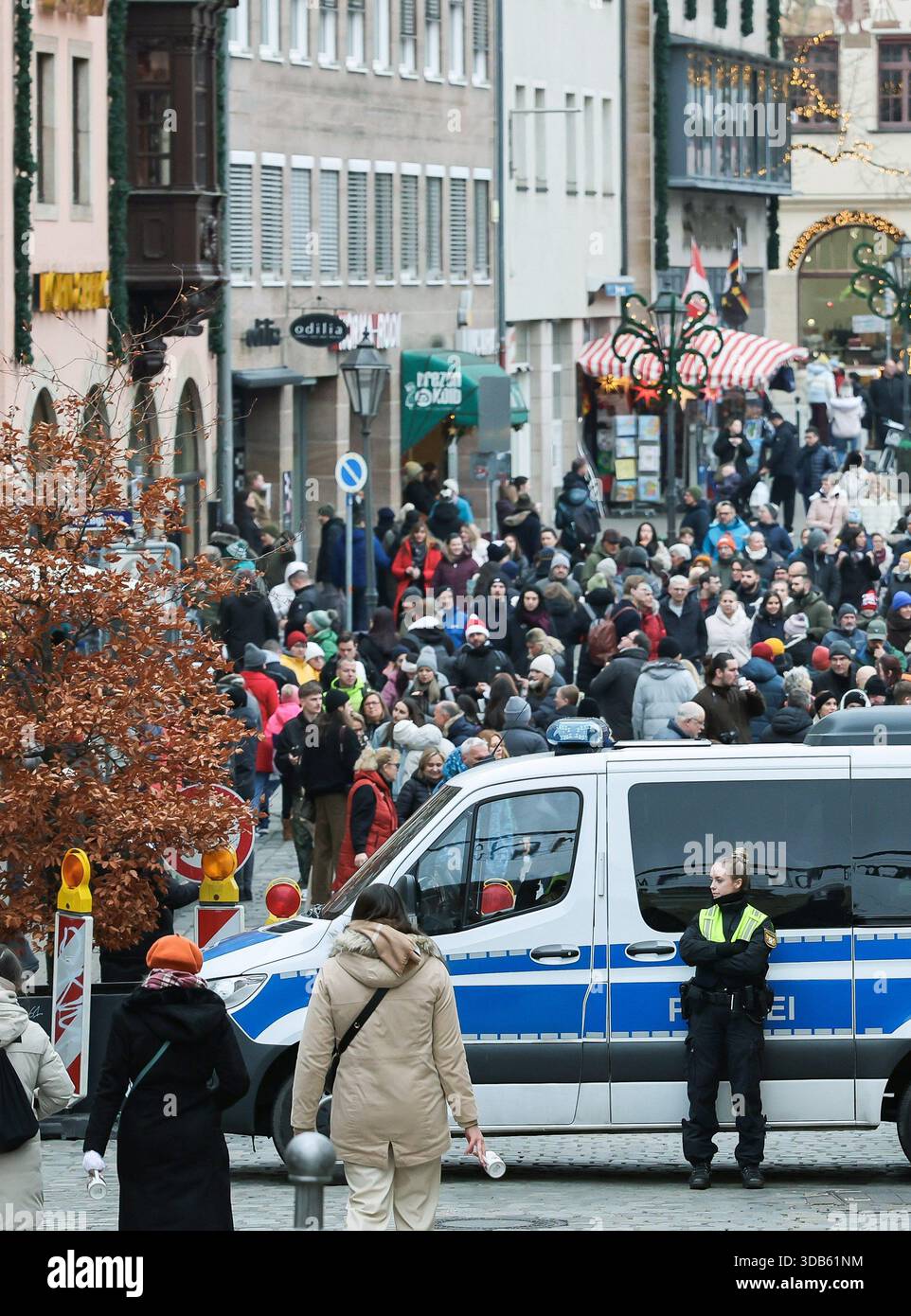 14 dicembre 2025, Baviera, Norimberga: La polizia si assicura l'ingresso al mercatino di Natale di Norimberga. Il ministro degli interni bavarese Herrmann (CSU) ha parlato domenica a Norimberga dell'arresto di diversi uomini nella bassa Baviera che avrebbero pianificato un attacco a un mercatino di Natale con un veicolo. Foto: Daniel Löb/dpa Foto Stock