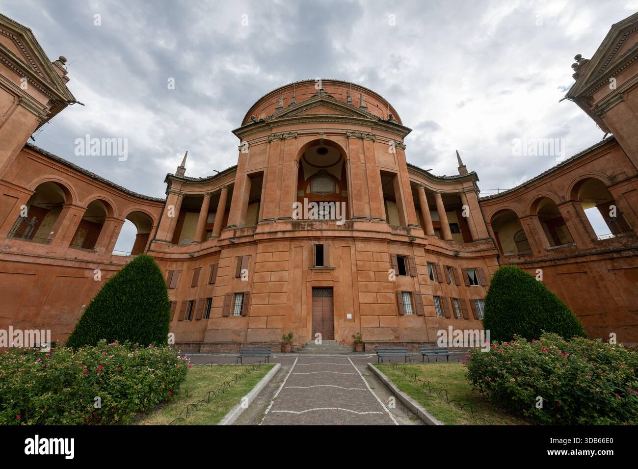 Vista dall'angolo basso della facciata barocca in mattoni del Santuario di nostra Signora di San Luca sul Colle della Guardia a Bologna. Foto Stock