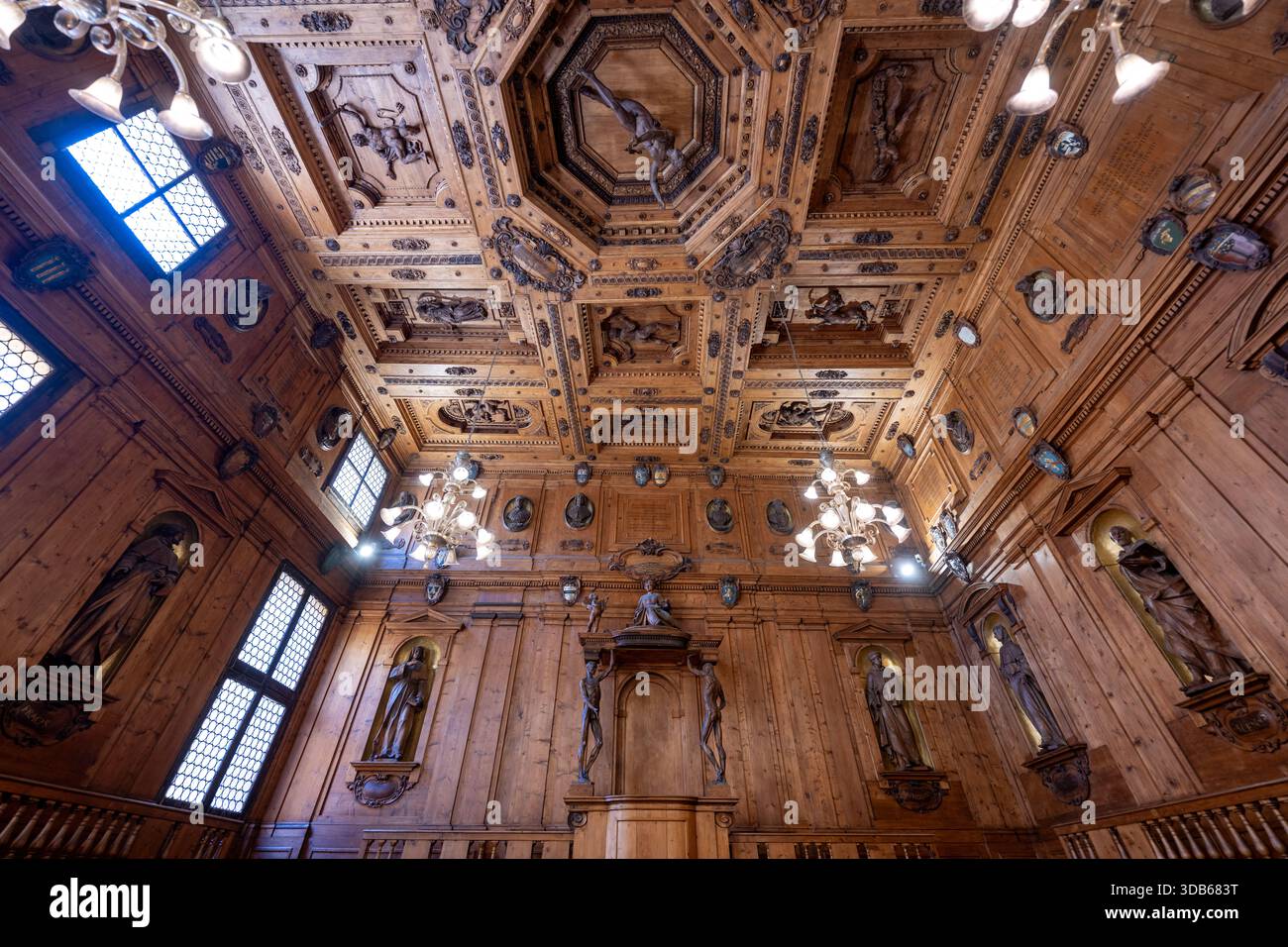 Bologna, Italia - 23 luglio 2025: Sala in legno decorata presso la Biblioteca Comunale Archiginnasio, Bologna, con soffitto a cassettoni intagliati, lampadari, e. Foto Stock