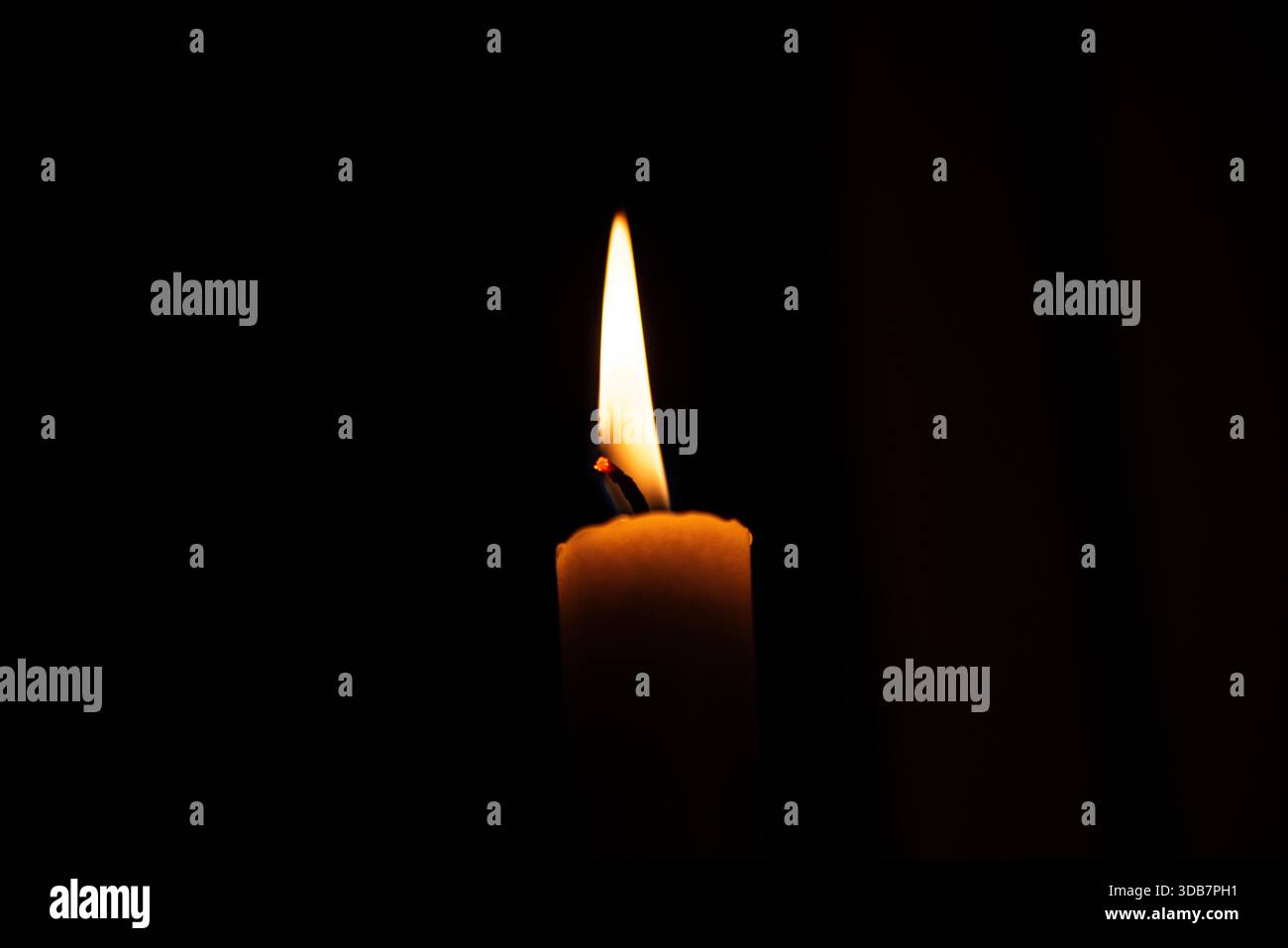 Una foto macro dettagliata di una fiamma di una candela, che cattura il caldo bagliore, il delicato sfarfallio e la texture atmosferica della cera ardente. Perfetto per i temi Foto Stock