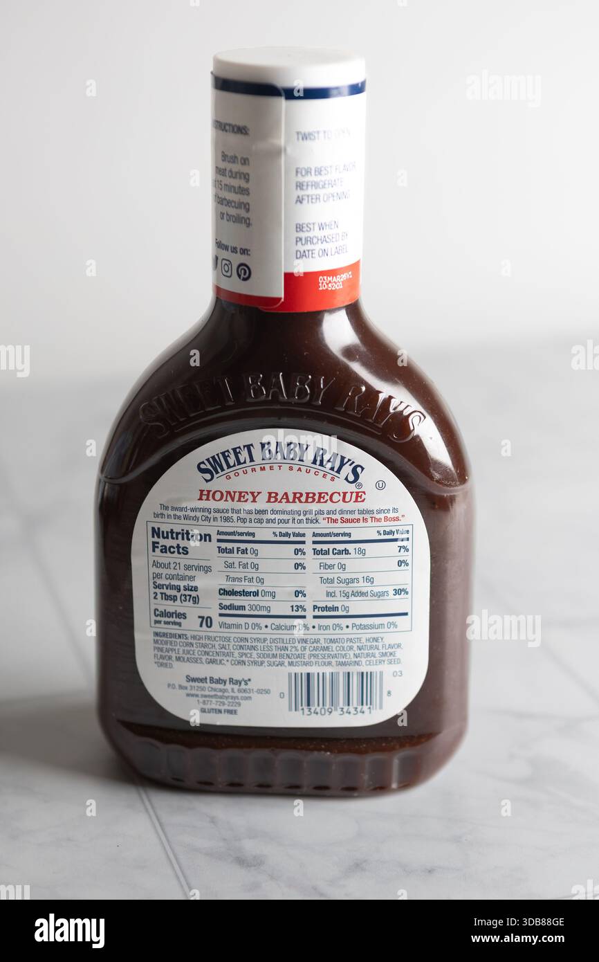 Elenco degli ingredienti della salsa al barbecue al miele di Sweet baby ray e informazioni nutrizionali su una superficie leggera della cucina Foto Stock