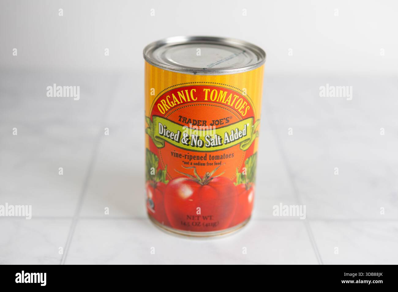 Il commerciante joe ha tagliato a dadini i pomodori in scatola biologici su una superficie della cucina Foto Stock