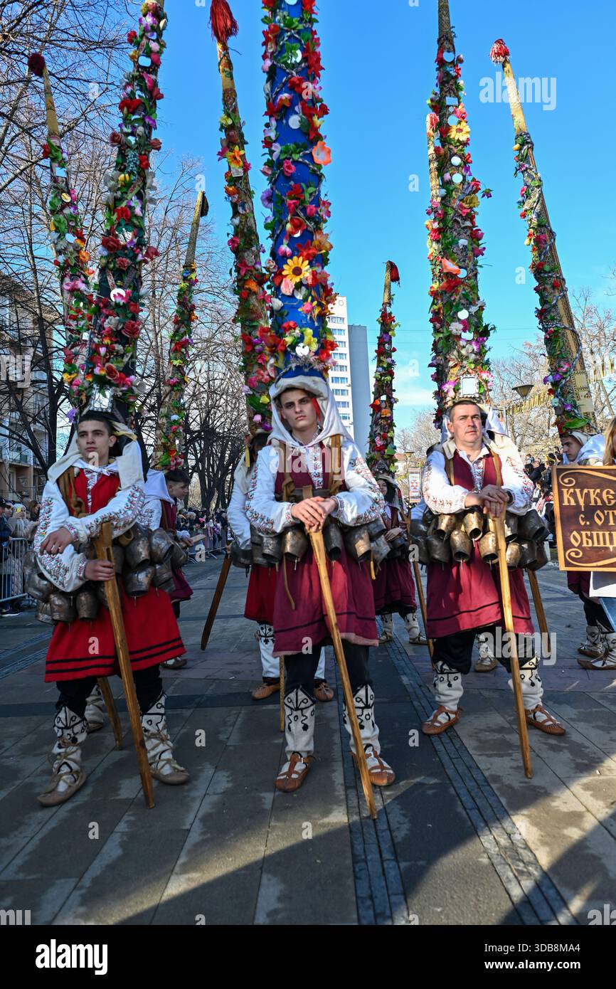 I membri del Kukeri Ensemble del villaggio di Otets Paisievo, comune di Kaloyanovo, Bulgaria, partecipano a una tradizionale processione in maschera Foto Stock