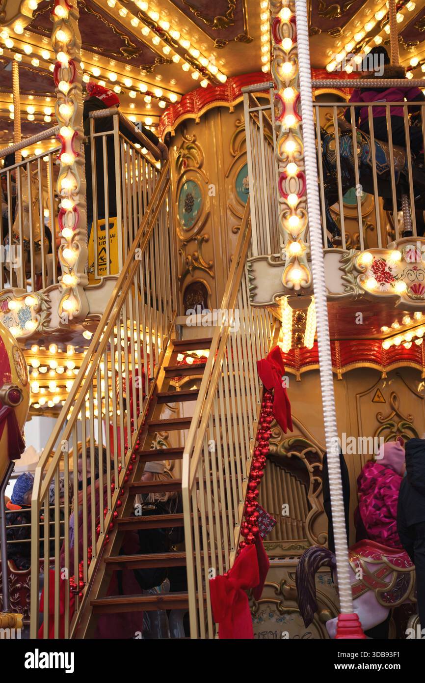 vibrante scalinata a giostra con decorazioni festose, che illumina un caldo bagliore di luci, invitando i visitatori a un magico giro tra dettagli ornati e j Foto Stock