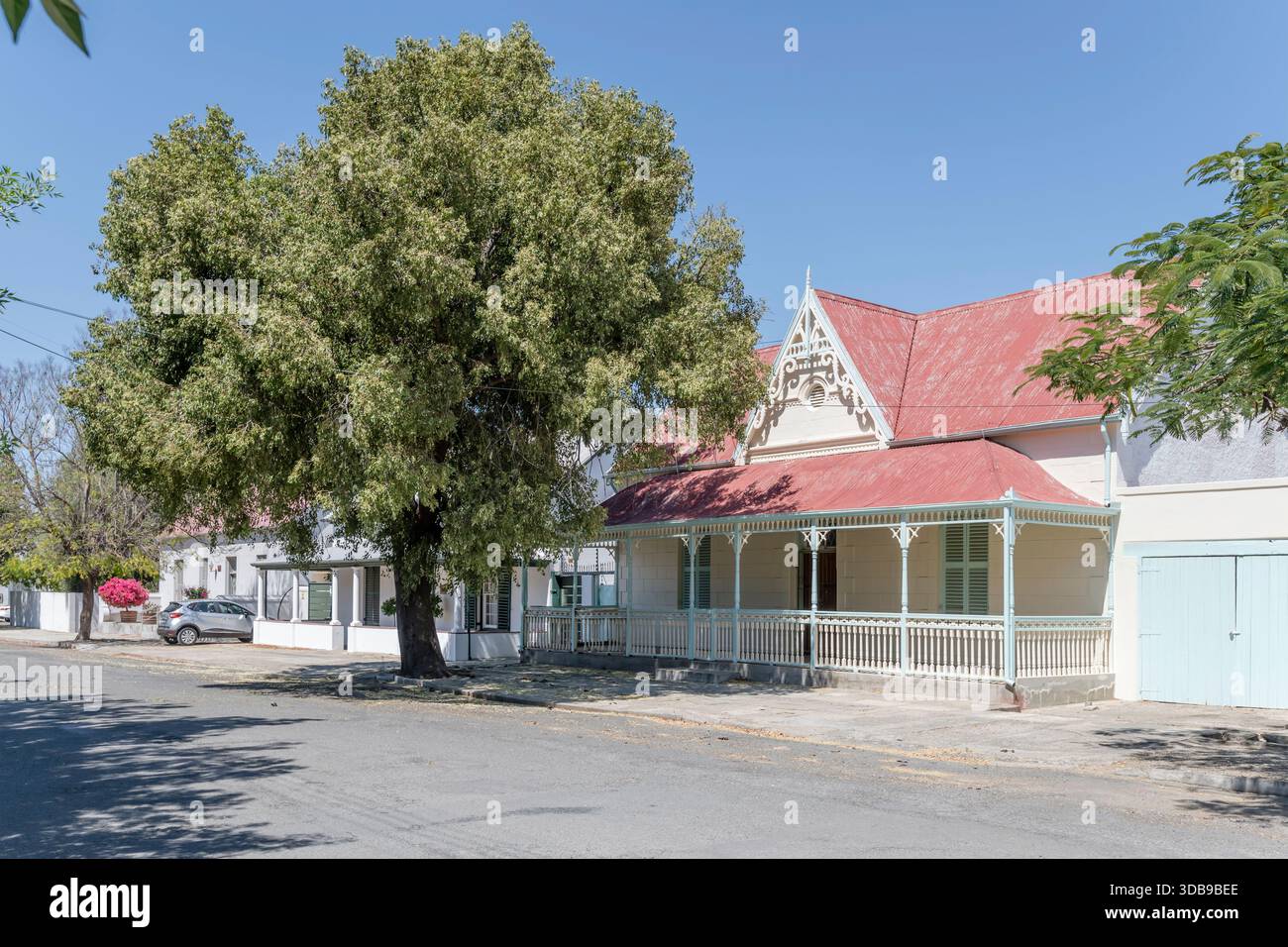 Paesaggio urbano con timpano in legno ornato e balaustra presso la tradizionale e pittoresca casa su strada alberata, girato con la luce della tarda primavera, Graaff-re Foto Stock
