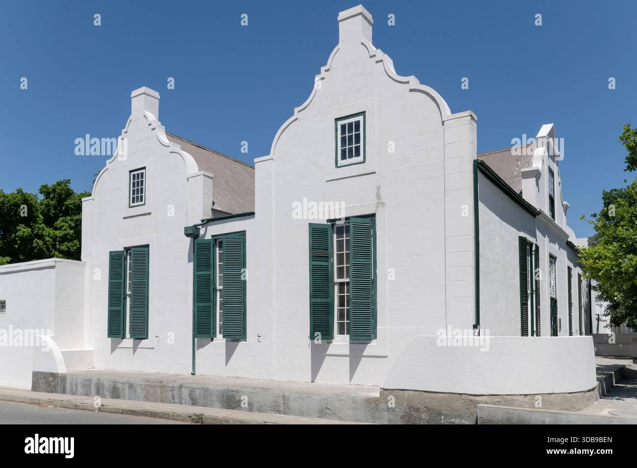 Paesaggio urbano con una tradizionale e pittoresca casa all'angolo di un incrocio, fotografata alla luce della tarda primavera, Graaff-Reinet, Capo Orientale, Sud Africa Foto Stock