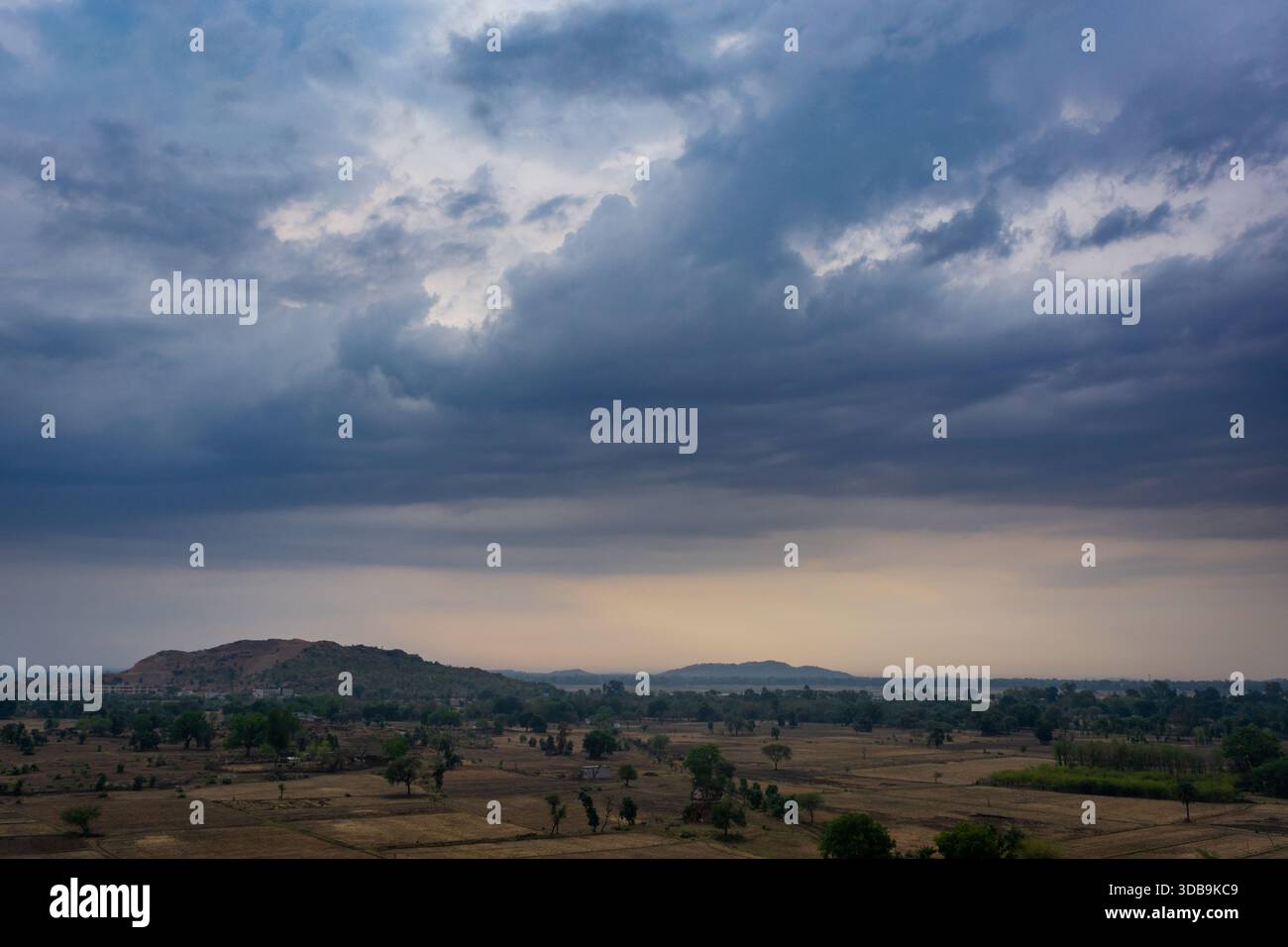 Spettacolari nuvole monsoniche sul tranquillo paesaggio rurale al crepuscolo Foto Stock