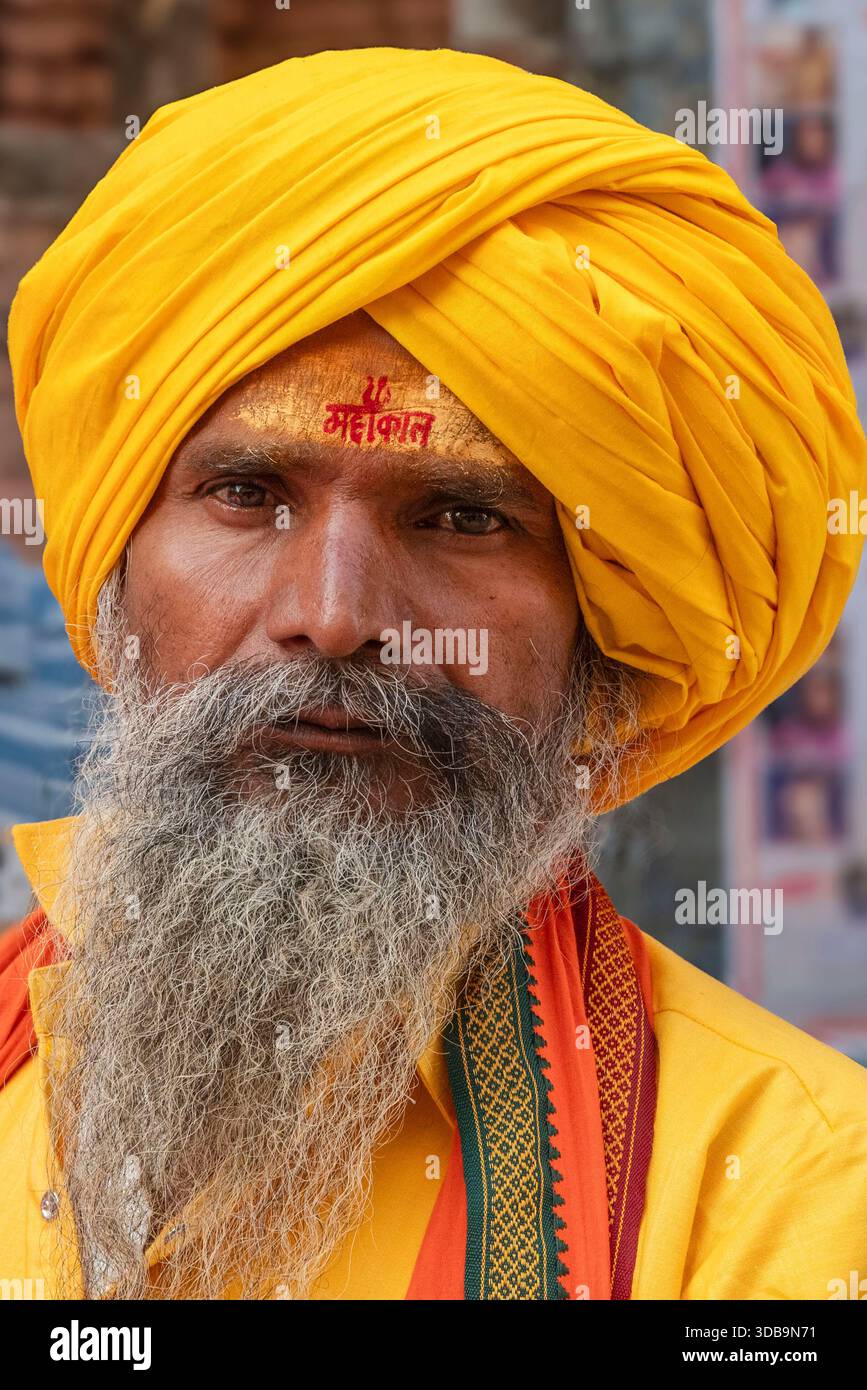 Ritratto di un sadhu indù in abiti gialli, che mostra espressione serena e presenza spirituale. Foto Stock